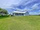 Exterior view of a charming home with a metal roof, set amidst a vast green lawn, creating a serene countryside setting at 1040 Timbers Dr, Fort Meade, FL 33841