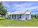 Charming single-story home with a metal roof and inviting front porch, set on a lush lawn at 1040 Timbers Dr, Fort Meade, FL 33841