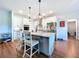 Charming kitchen boasts white cabinets, an island with pendant lighting, and stainless steel appliances at 1040 Timbers Dr, Fort Meade, FL 33841