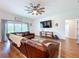 Bright living room features a cozy leather couch, wood-look flooring, and natural light from the sliding glass door at 1040 Timbers Dr, Fort Meade, FL 33841