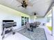 Covered patio featuring a grill, ceiling fans, and an outdoor dining area with scenic views, perfect for entertaining at 1040 Timbers Dr, Fort Meade, FL 33841