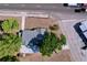 An aerial view of a gray roof home next to a road and store parking lot surrounded by several trees at 105 Old Connersville Rd, Bartow, FL 33830