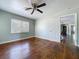 Bright bedroom featuring hardwood floors, neutral paint, a ceiling fan, and a sunlit window at 105 Old Connersville Rd, Bartow, FL 33830