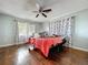 Bedroom with hardwood floors and a ceiling fan, featuring bright floral curtains at 105 Old Connersville Rd, Bartow, FL 33830