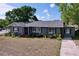 Charming single-story home with mature trees, gray exterior, blue shutters, and a well-lit entry at 105 Old Connersville Rd, Bartow, FL 33830