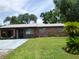 Inviting brick home with a lush green lawn, mature landscaping, and a spacious driveway at 112 Bishop St, Auburndale, FL 33823