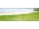 Scenic lake view featuring a sandy beach and lush green grass at 112 Bishop St, Auburndale, FL 33823