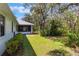 Lush backyard featuring a well-maintained lawn and mature trees providing ample shade at 1131 Country Oaks Blvd, Lake Wales, FL 33898