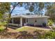 Scenic backyard view showcasing the home's exterior, screened-in porch, and landscaping at 1131 Country Oaks Blvd, Lake Wales, FL 33898