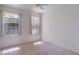 Bright bedroom featuring plush carpeting, white walls, and two windows for ample natural light at 1131 Country Oaks Blvd, Lake Wales, FL 33898