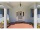 Covered front porch with brick flooring and decorative columns at 1131 Country Oaks Blvd, Lake Wales, FL 33898