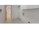 Practical laundry room featuring tile floors, storage cabinets, and access to the outdoors at 1131 Country Oaks Blvd, Lake Wales, FL 33898