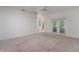 Bright living room with carpeting, white walls, ceiling fan, and glass doors offering outdoor views at 1131 Country Oaks Blvd, Lake Wales, FL 33898