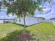 Backyard featuring a young shade tree, lush grass, and white privacy fence at 1205 Third Ct, Eagle Lake, FL 33839