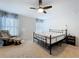 Bright bedroom featuring a ceiling fan, neutral carpet, and comfortable seating near patterned curtains at 1205 Third Ct, Eagle Lake, FL 33839