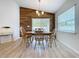 Bright dining room with wood accent wall, light floors and natural light at 1205 Third Ct, Eagle Lake, FL 33839