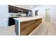 Kitchen featuring a large island with a wood-paneled accent and stainless steel appliances at 1205 Third Ct, Eagle Lake, FL 33839