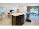 Stylish kitchen island featuring dark cabinets and stainless steel appliances in an open layout at 1205 Third Ct, Eagle Lake, FL 33839