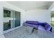Outdoor patio with wicker furniture, colorful cushions, and a sliding glass door at 1205 Third Ct, Eagle Lake, FL 33839