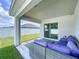 Relaxing covered patio area with a modern sectional sofa and privacy at 1205 Third Ct, Eagle Lake, FL 33839