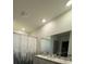 Bathroom featuring a double sink vanity, mirror, and a shower/tub combo with decorative shower curtain at 1414 Fox Squirrel Dr, Davenport, FL 33897