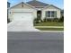 Charming single-story home with a well-manicured lawn, a two-car garage, and neutral paint at 1414 Fox Squirrel Dr, Davenport, FL 33897