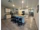 Bright kitchen features white cabinets, stainless steel appliances, island with bar seating and granite counters at 1414 Fox Squirrel Dr, Davenport, FL 33897