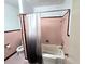 Bathroom featuring pink tile, a shower-tub combination with curtain, and toilet at 142 Se Ave B, Winter Haven, FL 33880