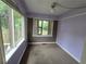 Bedroom with brown carpet, windows with tree views, and painted walls at 142 Se Ave B, Winter Haven, FL 33880
