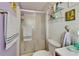 Bathroom featuring a shower with glass doors, decor and light purple walls at 1575 Longbow Dr, Lakeland, FL 33810