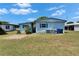 Side view of a blue home with blue shutters with lawn and garbage bins at 1575 Longbow Dr, Lakeland, FL 33810