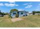 Side view of a blue home with blue shutters and a brick patio at 1575 Longbow Dr, Lakeland, FL 33810
