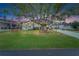 Charming home adorned with birdhouses and charming yard decor under a large tree during dusk at 1575 Longbow Dr, Lakeland, FL 33810
