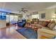 Comfortable living room featuring a ceiling fan, hardwood floors, and abundant natural light from the windows at 1575 Longbow Dr, Lakeland, FL 33810
