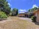 A spacious backyard features an open patio with lawn and ample greenery in a well-maintained landscape at 1600 Alma Ct, Bartow, FL 33830