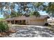A well-maintained single-story home boasts a large driveway and a two-car garage, framed by mature trees at 1600 Alma Ct, Bartow, FL 33830