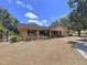 Charming single-story home featuring a well-maintained lawn, red shutters, and a paved driveway with attached garage at 1600 Alma Ct, Bartow, FL 33830