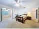 Bright main bedroom featuring a ceiling fan and an open doorway to a bonus room at 1600 Alma Ct, Bartow, FL 33830