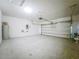 A spacious garage with concrete flooring, white walls, and an automatic garage door at 1835 Jackson Oaks Dr, Bartow, FL 33830