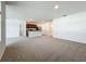Open-concept living room showcasing neutral carpeting, white walls, and kitchen view at 1835 Jackson Oaks Dr, Bartow, FL 33830