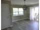 Open-concept living room with a modern light fixture and wood-look floors at 1835 Mount Pisgah Rd, Fort Meade, FL 33841