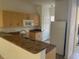 Functional kitchen features wooden cabinets, a breakfast bar, and a white refrigerator at 184 Ocean Bluff Dr, Poinciana, FL 34759
