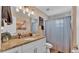 Well-lit bathroom featuring a vanity with granite counters and a shower with a black and white checked curtain at 1850 Saddlewood Pl, Bartow, FL 33830