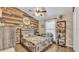 Inviting bedroom featuring a rustic accent wall, ceiling fan, and neutral tones for a relaxing atmosphere at 1850 Saddlewood Pl, Bartow, FL 33830