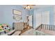 Stylish Bedroom with a modern crib, a rocking chair, and wood-look flooring creating a warm ambiance at 1850 Saddlewood Pl, Bartow, FL 33830