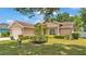 Traditional single-story home with a well-manicured lawn, mature landscaping, and an attached two car garage at 1850 Saddlewood Pl, Bartow, FL 33830