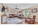 Comfortable living room with leather seating, light hardwood floors, and bright natural light from large windows at 1850 Saddlewood Pl, Bartow, FL 33830