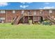 Brick building with a spacious backyard and wooden staircases leading to upper-level balconies at 1920 E Edgewood Dr # D7, Lakeland, FL 33803