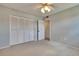 Empty bedroom with carpet, ceiling fan, closet, and attached door to a utility room at 1920 E Edgewood Dr # D7, Lakeland, FL 33803