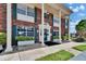 Exterior view of a two-story red brick building with white columns and green shutters at 1920 E Edgewood Dr # D7, Lakeland, FL 33803
